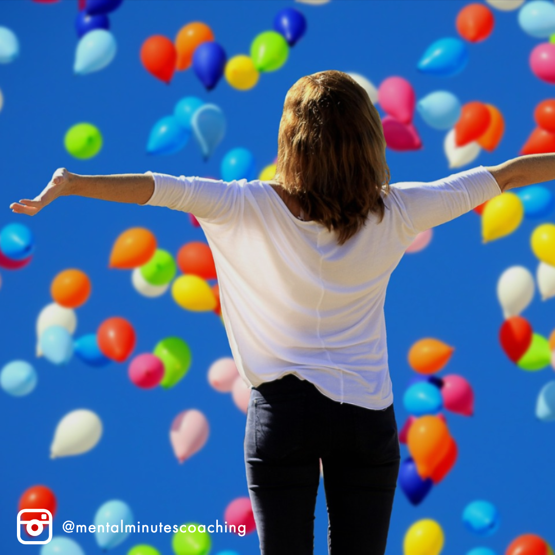 woman with hands out while balloons float by